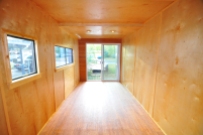 Completed interior of container with plywood wall panels and resilient flooring